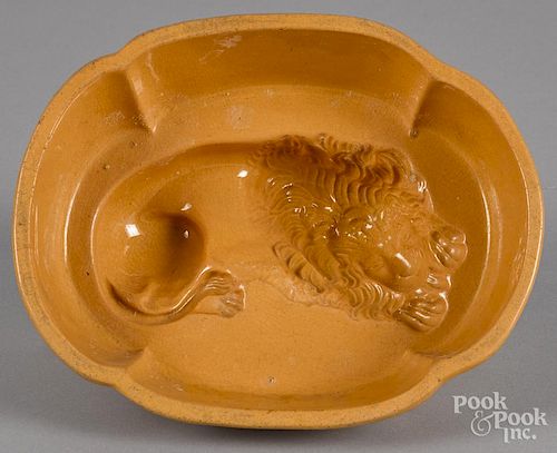 Yellowware lion food mold, 19th c., 3 1/4'' h., 8 1/4'' w., 6 5/8'' d.