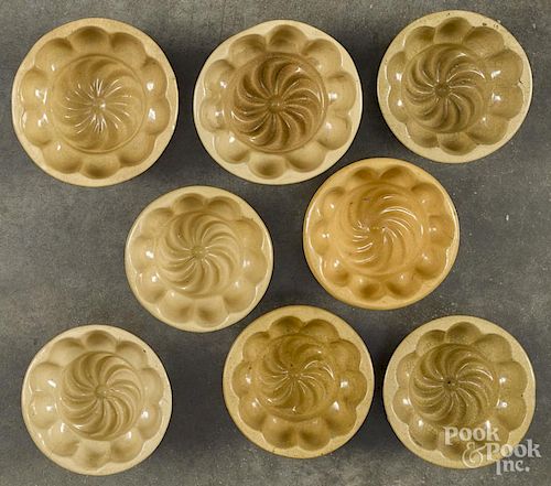 Eight yellowware food molds, 19th c., with swirl centers, approx. 2 1/4'' h., 4 1/4'' w.