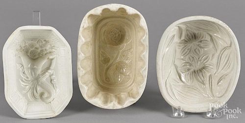 Two floral pattern food molds, together with a cornucopia example, largest - 3 1/2'' h., 7'' w.