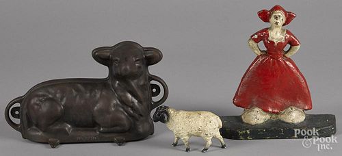 Cast iron lamb food mold, 7 1/4'' h., 11 1/2'' w., together with a Dutch girl doorstop