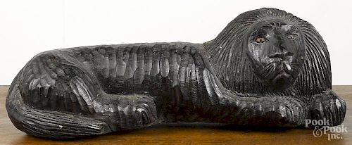 Carved mahogany reclining lion, 16'' l.
