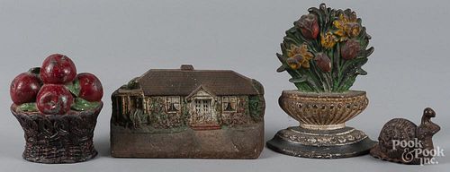 Two cast iron doorstops, ca. 1900, together with a lead basket of fruit doorstop and an iron snail