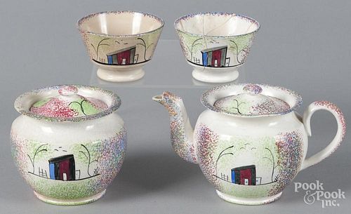 Miniature rainbow spatter teapot with a shed, together with a matching sugar and two cups.