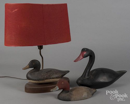 Duck decoy table lamp, together with a carved and painted black swan and a cast iron duck doorstop.
