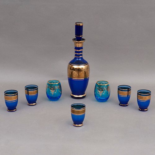 SET DE LICORERA SIGLO XX Elaborados en cristal color azul Detalles en esmalte dorado Consta de licorera, 5 vasos a juego y 2...