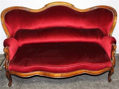 A Victorian Style Walnut Camelback Settee Height 42 x width 68 x depth 36 inches.