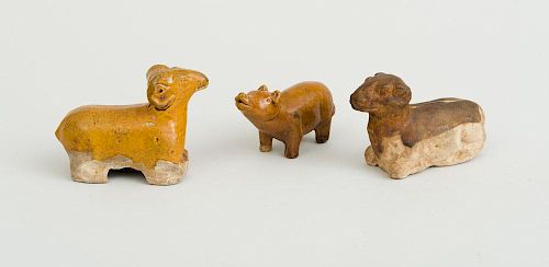 TANG TYPE OCHRE-GLAZED POTTERY FIGURE OF A SEATED RAM, AN UNGLAZED RAM AND AN OCHRE-GLAZED FIGURE OF A PIG