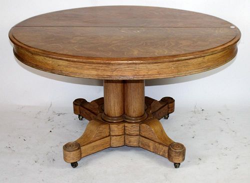 American round oak pedestal table with 3 leaves.