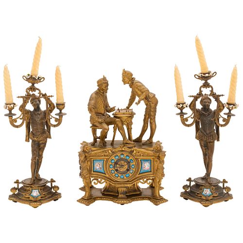 GUARNICIÓN. EUROPA, PRINCIPIOS DEL SIGLO XX. Fundición en metal dorado con placas de porcelana. Reloj de chimenea y par de candelabros.