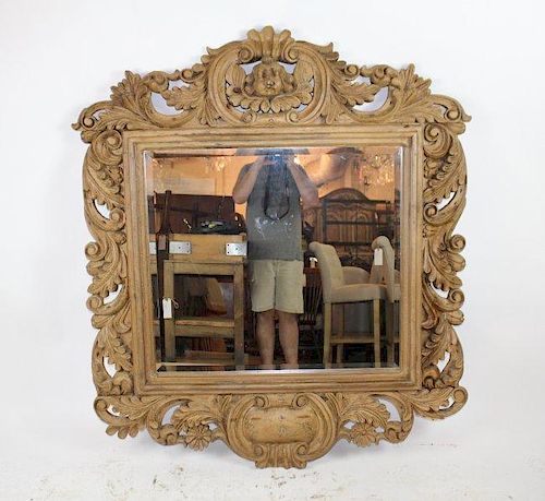 Rococo style carved mirror in natural finish with focal cherub