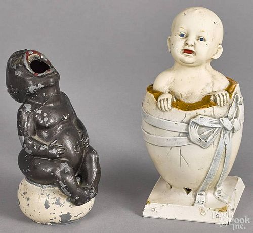 Enameled iron baby in an egg still bank, 7 1/4'' h., together with a spelter figure of a baby