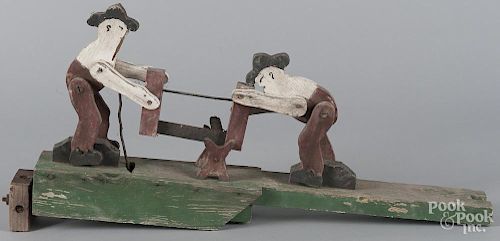 Painted pine whirligig, early 20th c., of two men sawing wood, 25'' l.