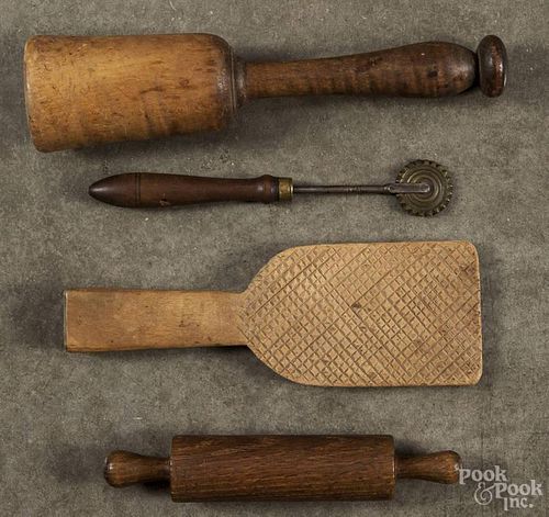 Group of woodenware, 19th c., to include a tiger maple masher, a small rolling pin, a carved butter