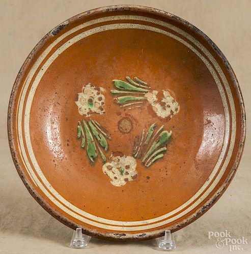 Continental redware shallow bowl, 19th c., with green and white slip floral decoration, 2 1/2'' h.