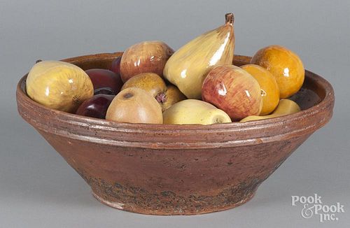 Redware bowl, 19th c., 4 1/2'' h., 13 1/2'' dia., together with wooden and pottery fruit.