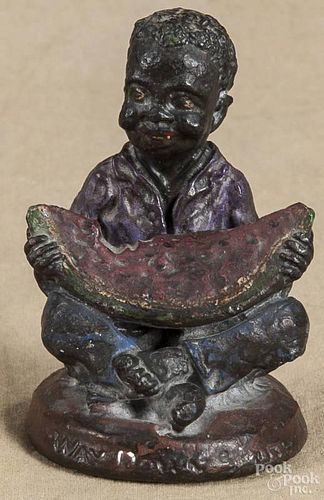 Cast iron black Americana paperweight of a child, ca. 1900, inscribed Way Down South, 4'' h.