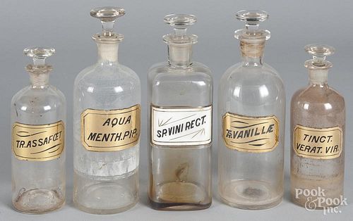 Five colorless glass apothecary bottles, tallest - 10 1/4''.
