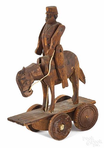 Carved pine articulated Hessian soldier on horseback pull toy, ca. 1900, 7 3/4'' h.