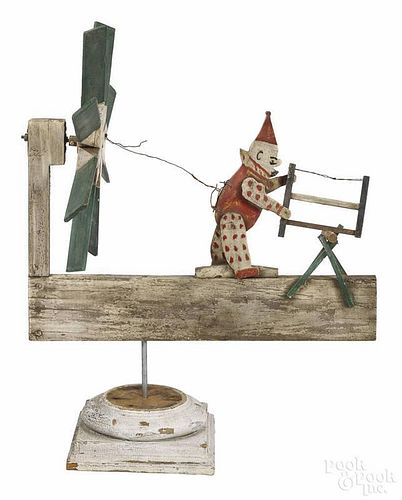 Carved and painted pine whirligig of a clown sawing wood, early 20th c., 24'' l.