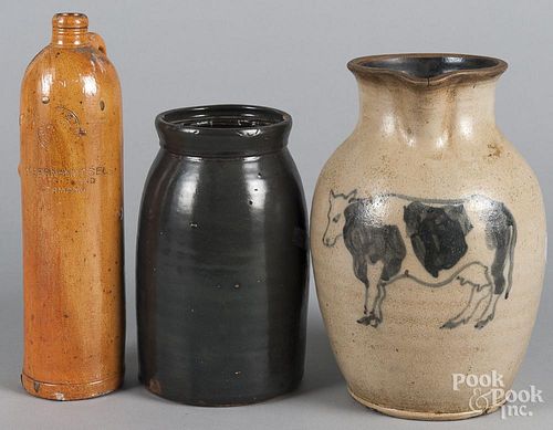 Three pieces of stoneware, to include a modern pitcher with cow decoration, a German bottle
