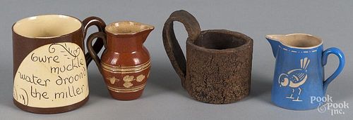 Two pottery creamers, together with a frog mug and a sewer tile mug.