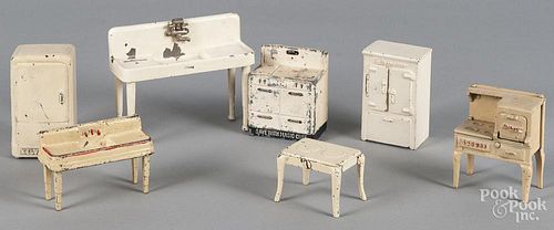Seven pieces of Arcade doll house appliances and furniture.