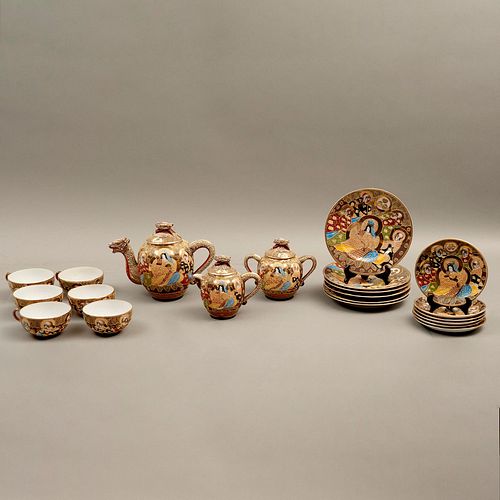 JUEGO DE TÉ JAPÓN SIGLO XX Elaborado en porcelana Satsuma Decoración en relieve con esmalte dorado sobre fondo café Consta...