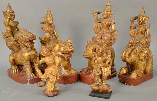 Set of six Southeast Asian polychrome and gilt decorated wood figures to include set of four figures on the back's of animals