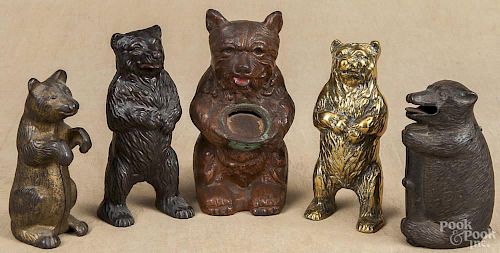 Four cast iron bear penny banks, together with a brass example, tallest - 6 1/2''.