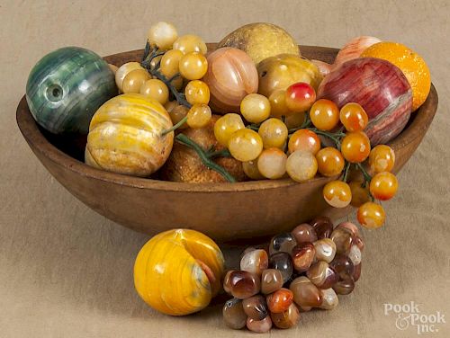 Turned wooden bowl, 19th/20th c., 12'' dia., together with a collection of stone and alabaster fruit.