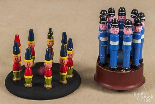 Set of nine painted skittles of English Bobbies, 20th c., 5 1/4'' h., on a painted stand