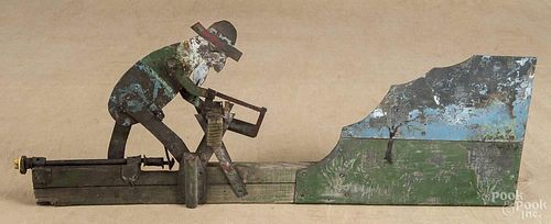 Painted galvanized tin whirligig, early 20th c., with a man sawing wood, 23'' l.