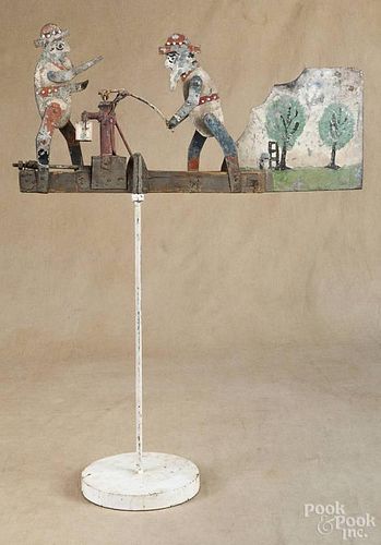 Painted galvanized tin whirligig, early 20th c., with two men at a well pump, 22'' l.