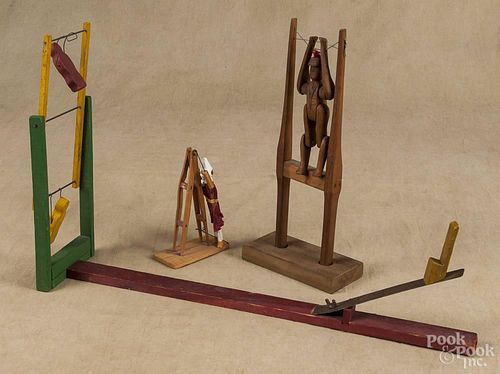 Painted wood clown flip toy, early 20th c., 23'' l., together with two carved wood acrobat toys