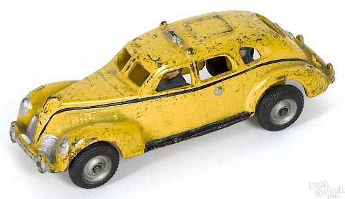 Arcade cast iron yellow cab with a painted driver and a passenger, 8'' l.