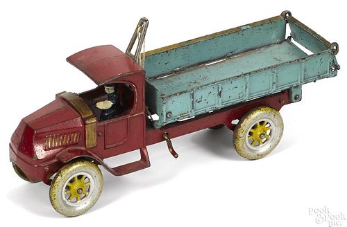 Kenton cast iron dump truck with a painted driver and painted steel wheels, 15'' l.