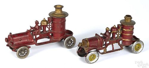 Two A.C. Williams cast iron fire pumpers with integral cast drivers, 10 1/2'' l. and 9 1/2'' l.