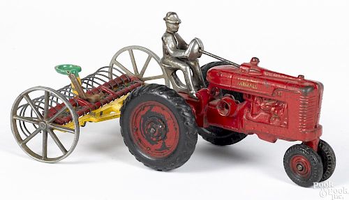 Arcade cast iron Farmall tractor, with a rake and a nickel-plated driver, tractor - 7'' l.