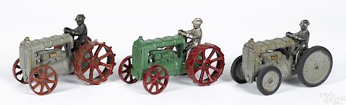 Three Arcade cast iron Fordson tractors with nickel-plated drivers, one is W & K, 6'' l.