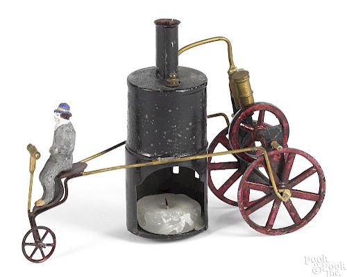 Schoenner steam powered tricycle with tin stained cast metal wheels, a candle powered boiler