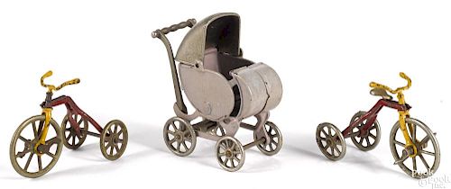 Two Kilgore cast iron tricycles, 3 3/4'' h., together with a Kilgore baby carriage, 5 1/2'' h.
