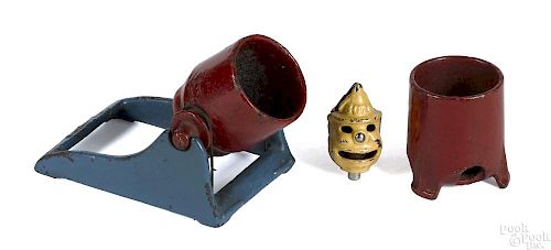 Two cast iron Fire Cracker Cannons, 3'' h., together with a Bozo clown cap bomb, 1 3/4'' h.