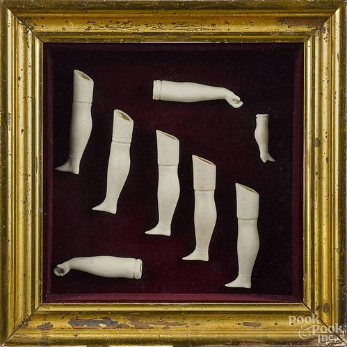 Framed group of bisque doll arms and legs, late 19th c.