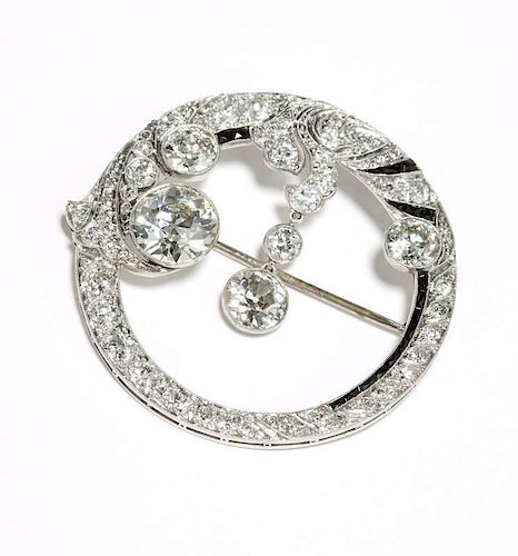 An Art Deco diamond and onyx circle brooch