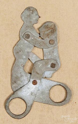Erotic tin scissor toy, 20th c., 6 1/2'' h., together with an erotic brass Ashanti gold weight