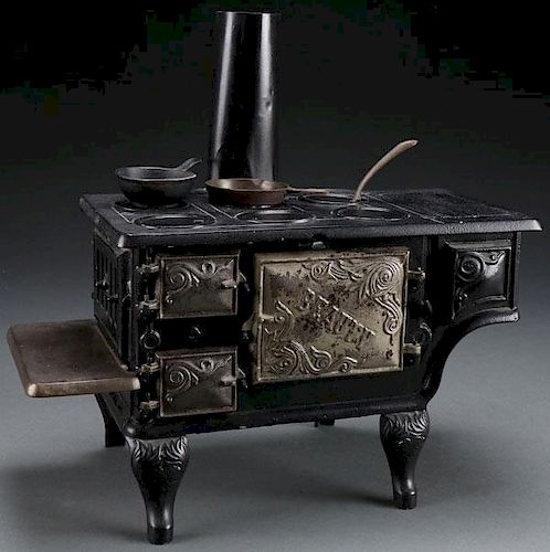 A CHILD'S CAST IRON TOY “BEAUTY” COOK STOVE