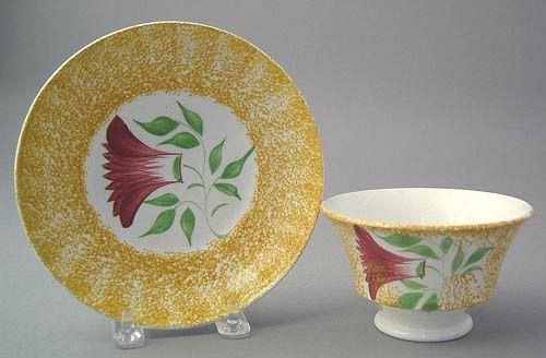 Yellow spatter cup and saucer with red thistle.