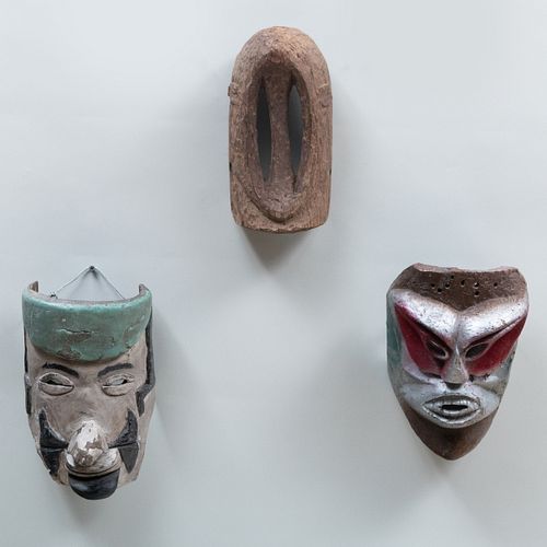 Two Painted Wood Masks with an African Carved Wood Mask