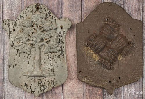Two cast iron fire marks, 20th c., mounted to wood plaques, 16'' h. and 16 1/2'' h.