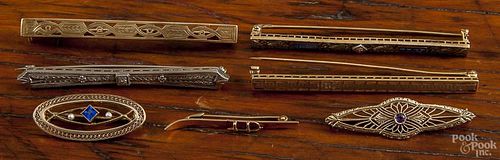Seven bar pins, to include 14K and 10K yellow and white gold, filigree styles as well as a ski motif